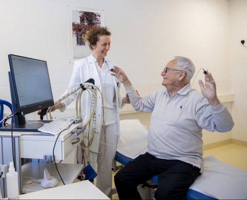 Patient erhält während Untersuchung Anweisung zum Arme heben