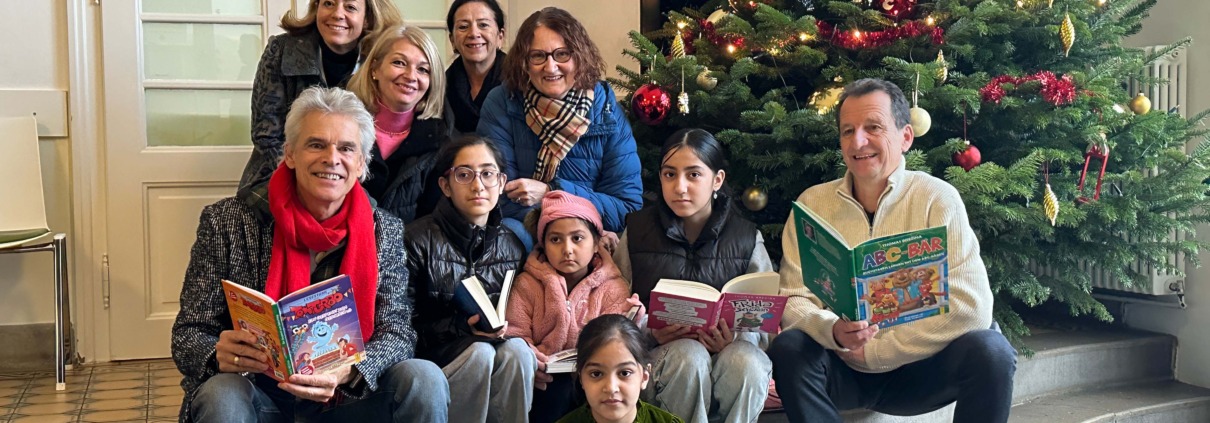 KOR Thomas Brezina besucht Kinder im Spital und liest aus seinen Büchern vor. Im Bild mit vielen Kindern, Mitarbeiter*innen und der lokalen Politik