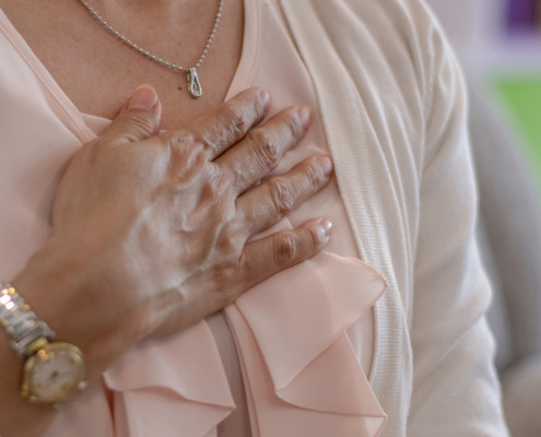 Frau hält sich Hand aufs Herz